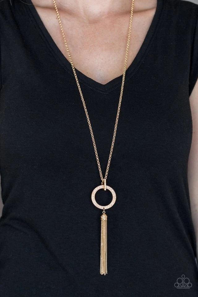 Paparazzi Accessories Straight To The Top - Gold Encrusted in dazzling peach rhinestones, a shimmery gold hoop swings from the bottom of an elegantly elongated gold chain for a refined look. A glistening gold tassel swings from the bottom of the glittery