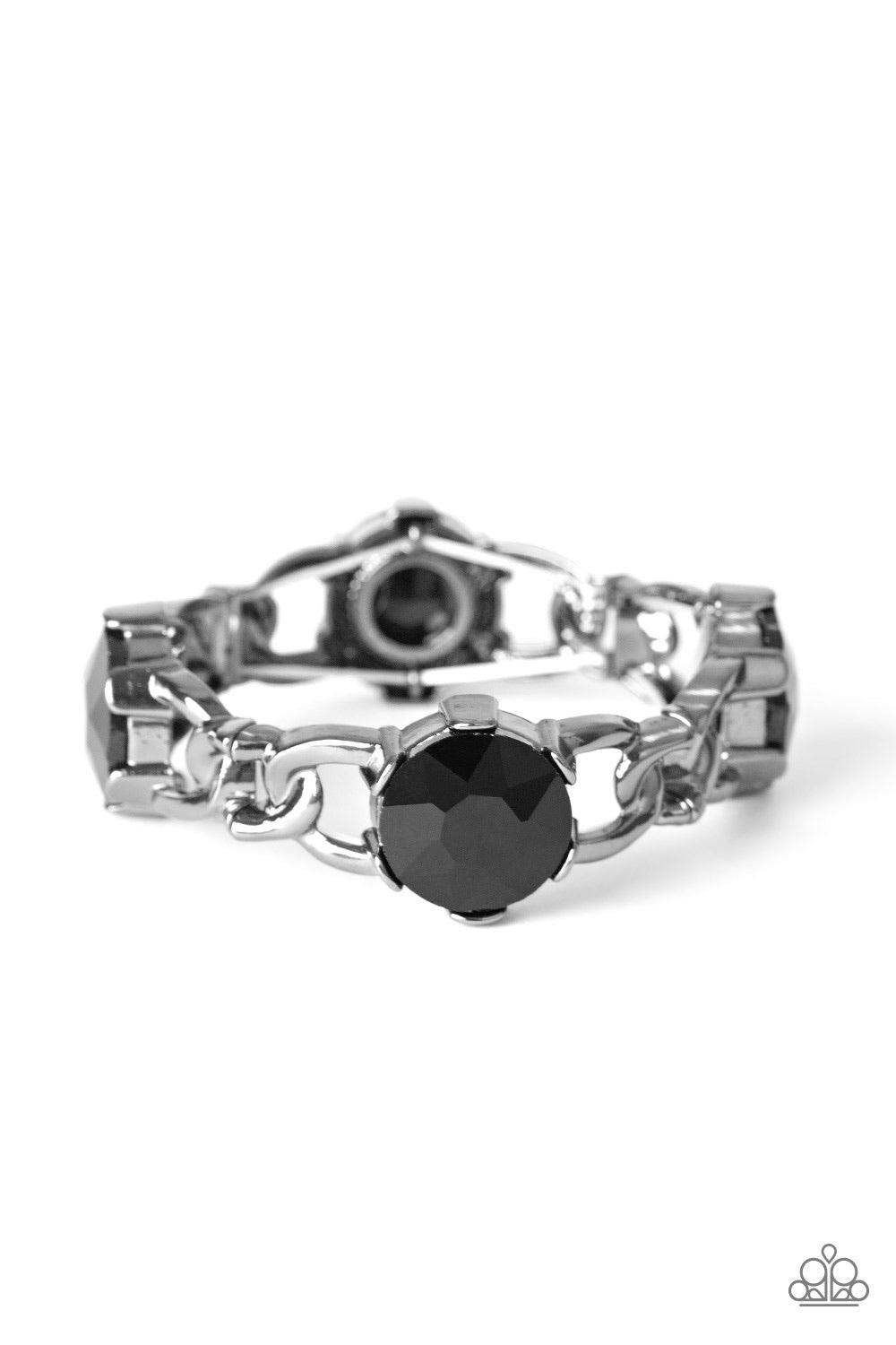 Paparazzi Accessories Light Up The Room - Black Featuring glistening gunmetal chain-link fittings, oversized black gem encrusted frames are threaded along a stretchy band around the wrist for a dramatic look. Jewelry