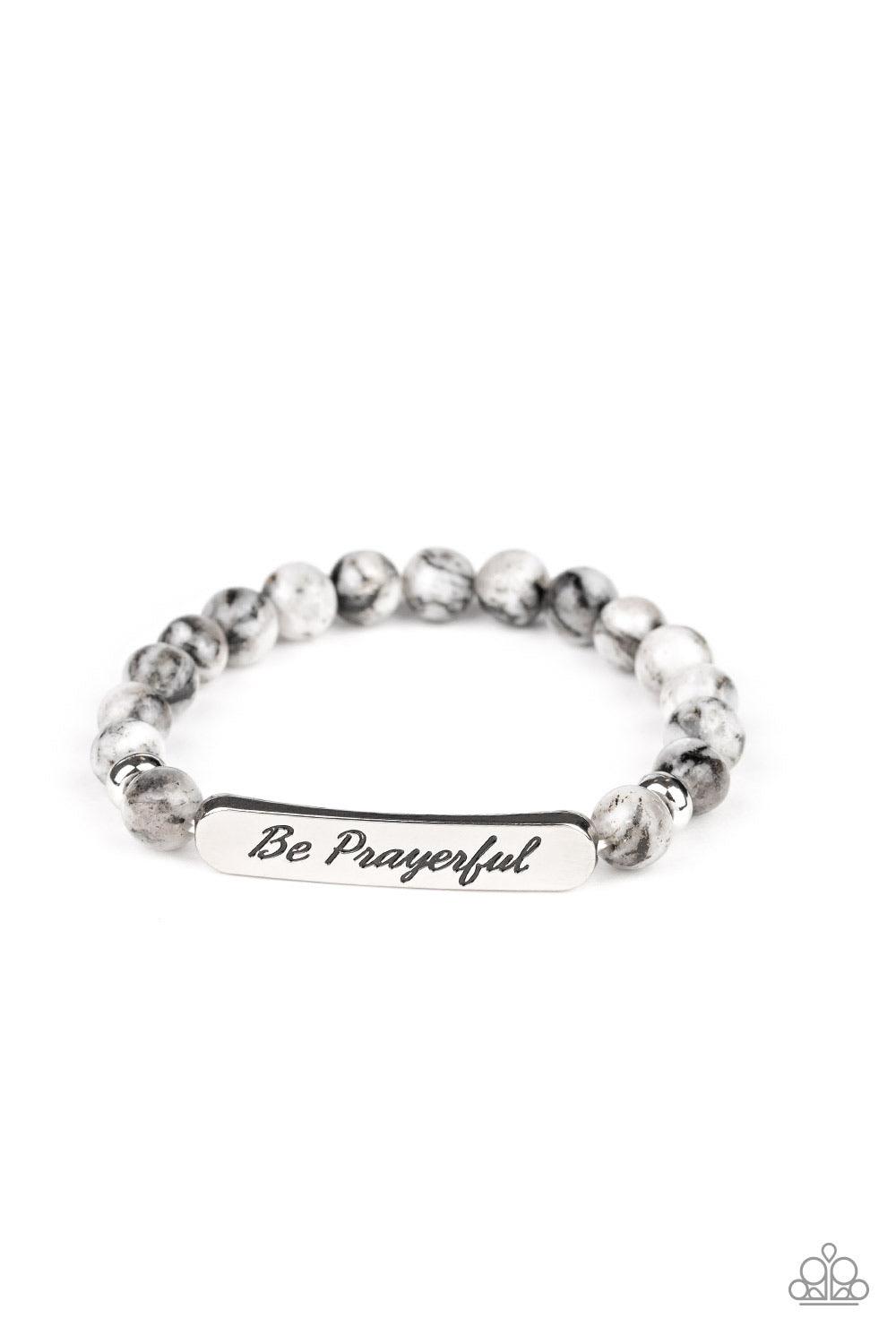 Paparazzi Accessories Be Prayerful - Black Infused with dainty silver accents, a collection of glassy black and white stone beads and a shimmery silver frame stamped in the phrase, "Be Prayerful", are threaded along a stretchy band around the wrist for an