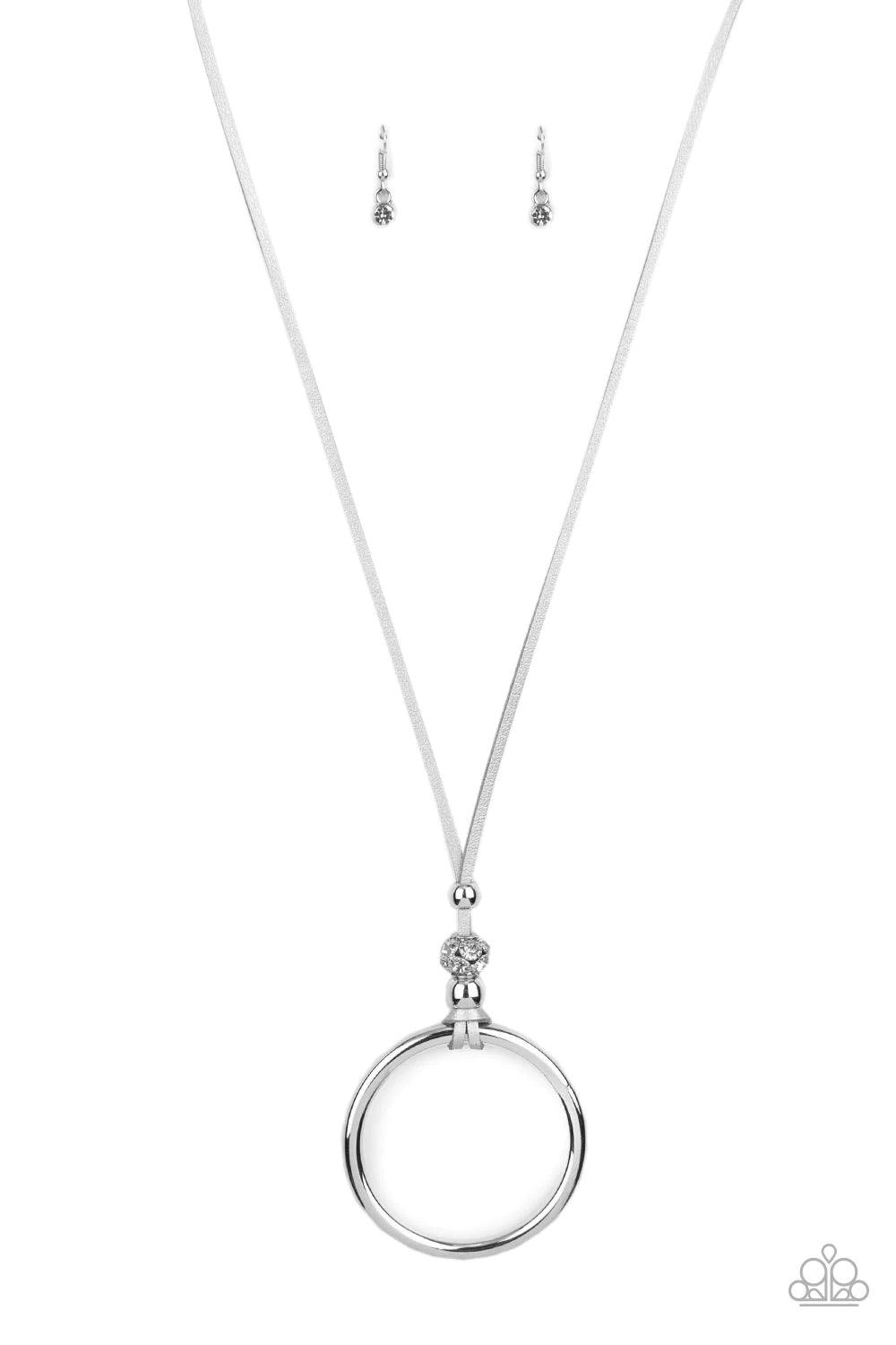 Paparazzi Accessories BLING Into Focus - Silver Infused with a pair of classic silver beads and a white rhinestone encrusted accent, lengthened shimmery silver leather cording knots around a bold silver hoop for a knockout look. Features an adjustable cla