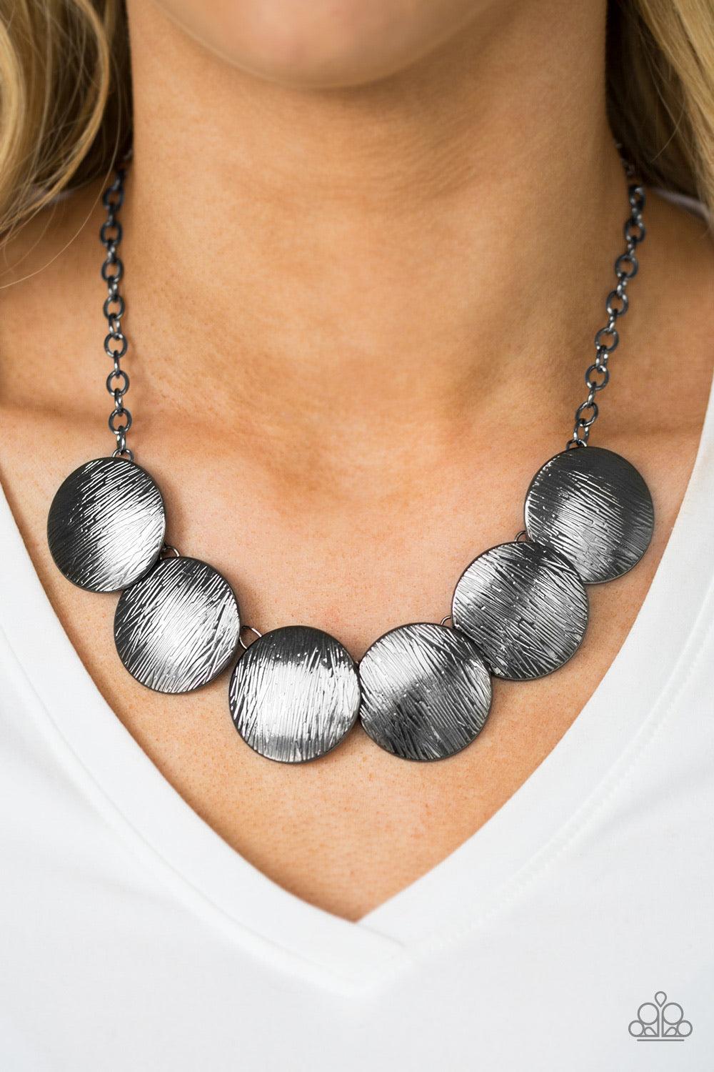 Paparazzi Accessories Glued To The SPOTLIGHT - Black Embossed in shimmery linear patterns, round gunmetal frames link below the collar for a bold industrial look. Features an adjustable clasp closure. Sold as one individual necklace. Includes one pair of