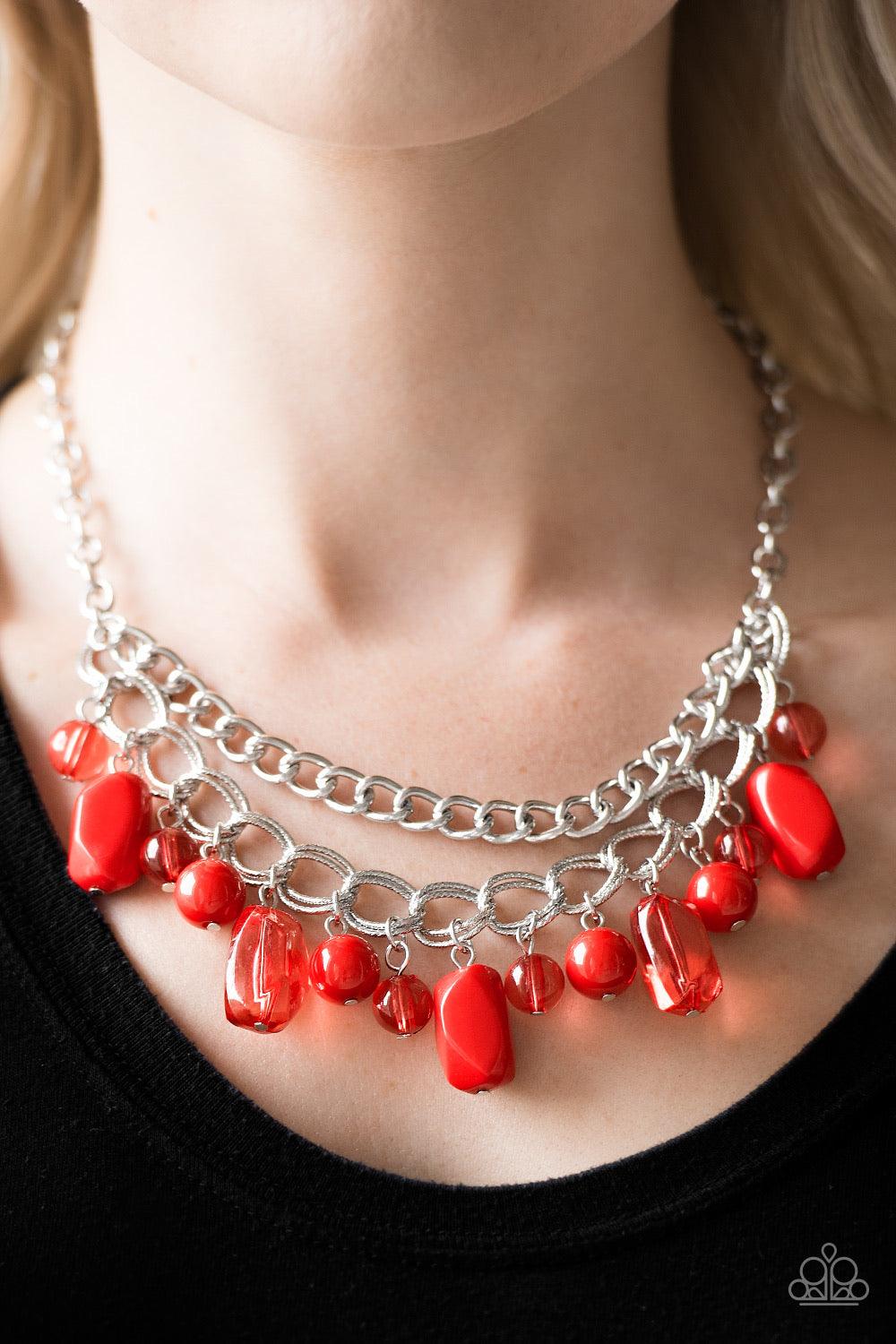 Paparazzi Accessories Brazilian Bay - Red Featuring glassy and polished finishes, round and asymmetrical red beads trickle from the bottom of a double-linked silver chain. An additional silver chain is layered above the summery beading for a seasonal fini