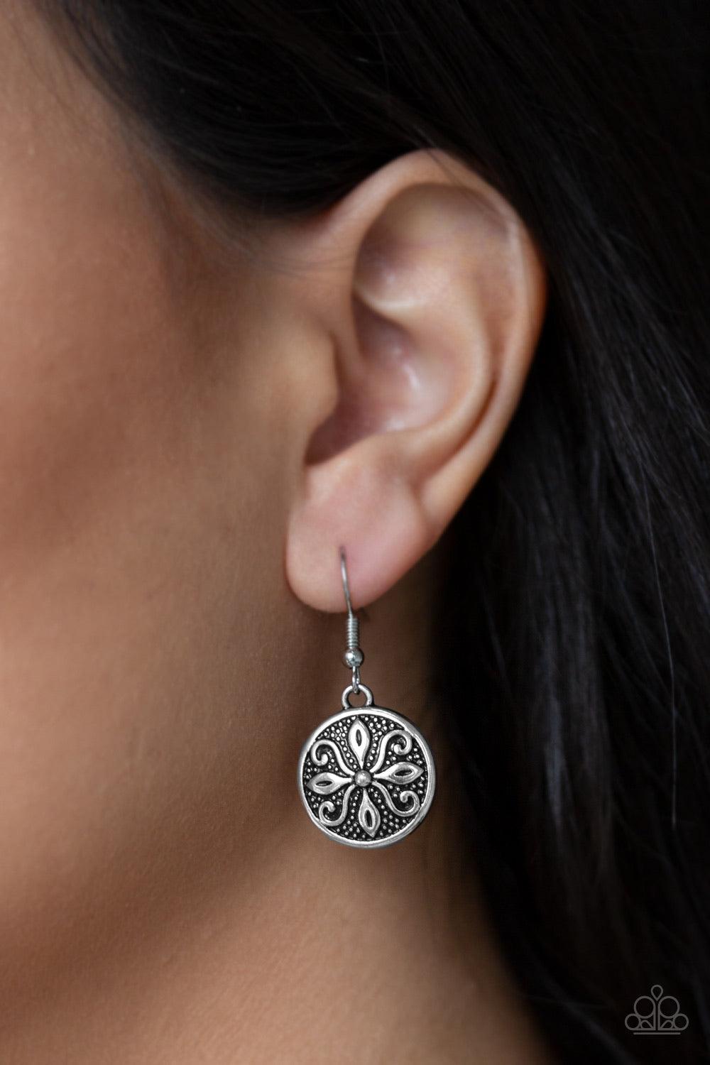 Paparazzi Accessories Tropical Trance ~Silver Brushed in an antiqued shimmer, a dainty silver disc is embossed in a frilly tactile pattern for a seasonal flair. Earring attaches to a standard fishhook fitting.