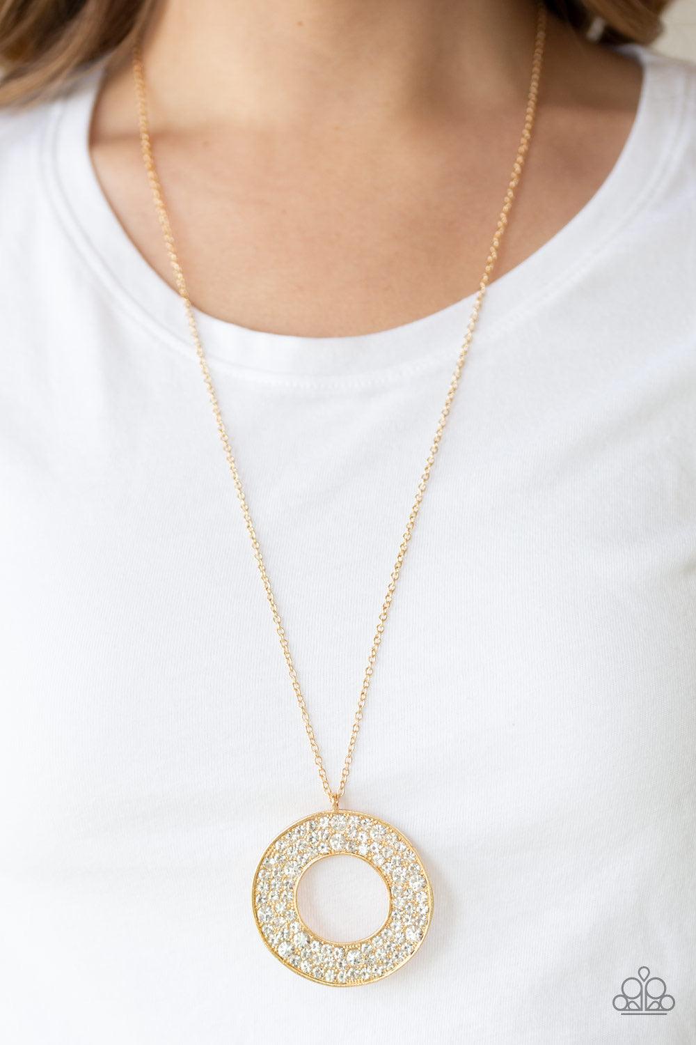 Paparazzi Accessories Bad HEIR Day - Gold Encrusted in row after row of glittery white rhinestones, an oversized round pendant swings from the bottom of a lengthened gold chain for a blinding look. Features an adjustable clasp closure. Jewelry
