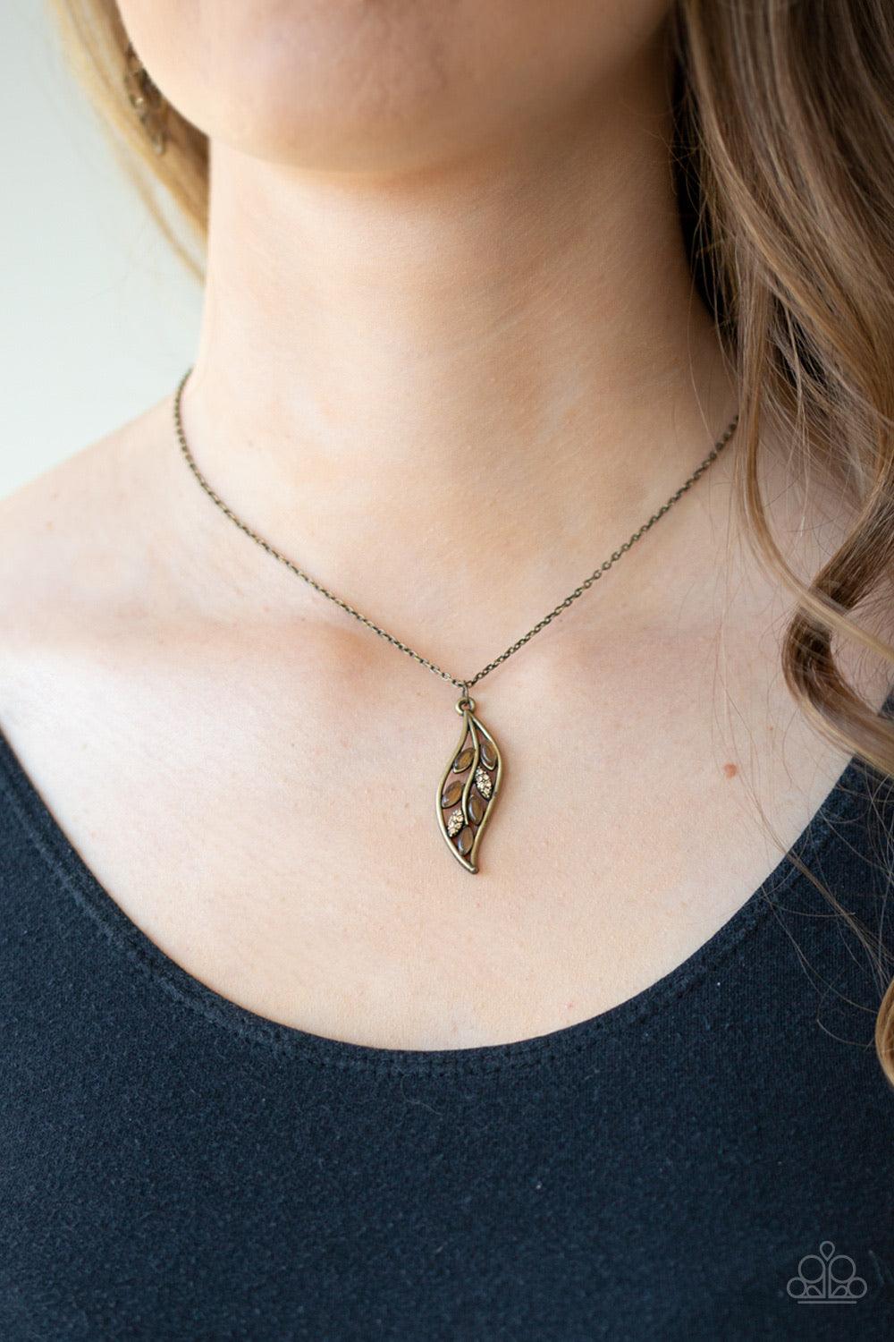 Paparazzi Accessories Let STEM Talk - Brass Glowing brown cat's eye stones and glassy white rhinestones are sprinkled along a leafy brass frame, creating a whimsical pendant below the collar. Features an adjustable clasp closure. Sold as one individual ne