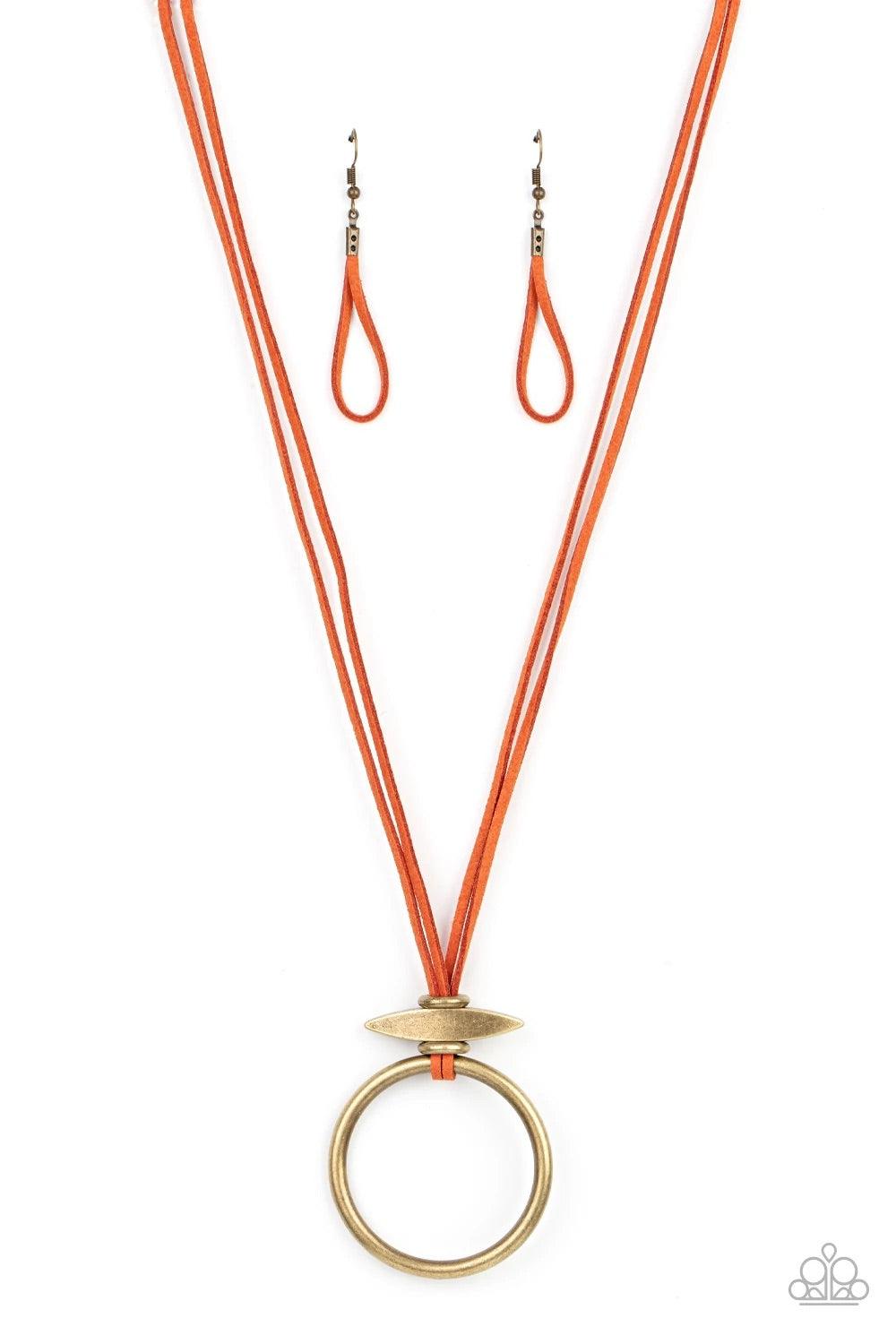 Paparazzi Accessories Noticeably Nomad - Orange Flanked by dainty brass rings, a marquise shaped brass bead glides along lengthened strands of rustic orange suede, holding in place an oversized brass ring at the bottom for an artisan inspired fashion. Fea