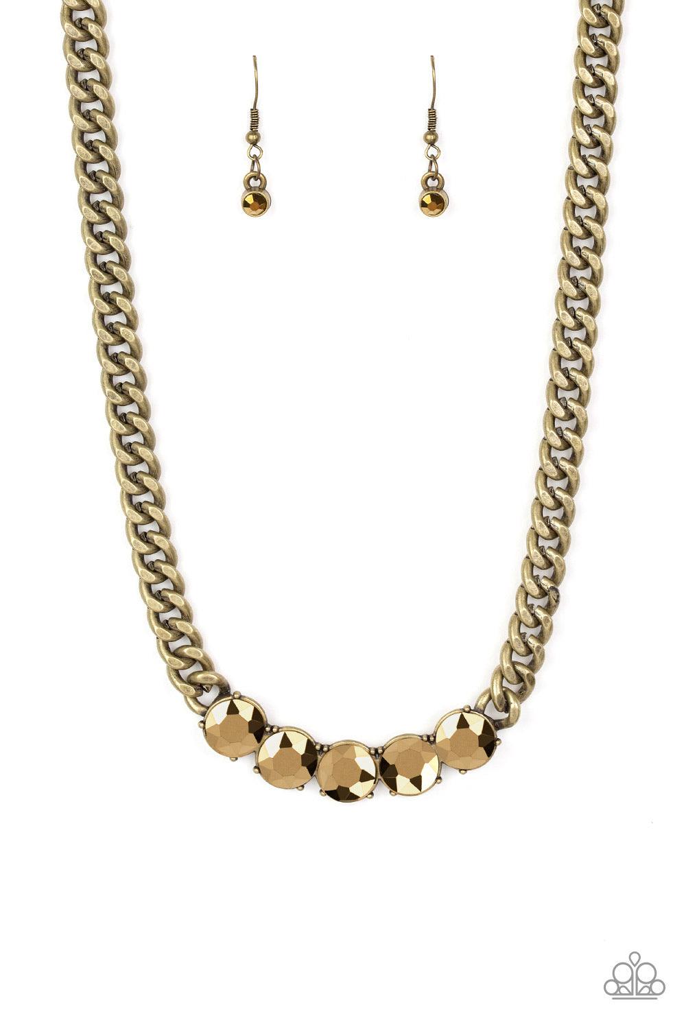 Paparazzi Accessories Rhinestone Renegade - Brass A thick brass chain gives way to a dramatic row of glittery aurum rhinestones, creating a bold and blinding statement below the collar. Features an adjustable clasp closure. Jewelry