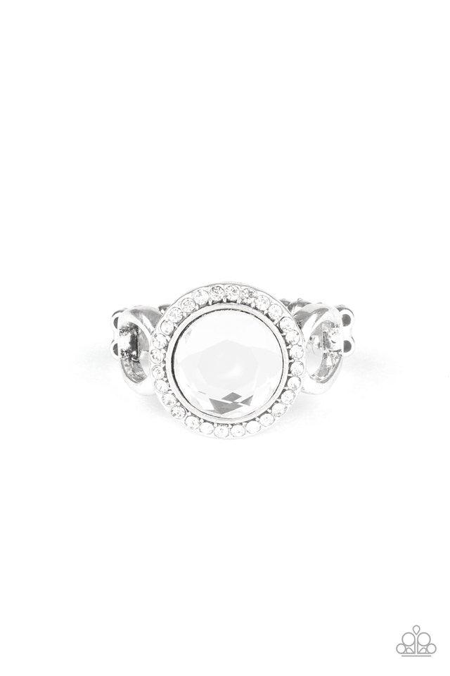 Paparazzi Accessories It’s Gonna Glow! - White An oversized white gem is pressed into the center of a round silver frame encrusted in a ring of radiant white rhinestones for a regal flair. Features a dainty stretchy band for a flexible fit. Sold as one in