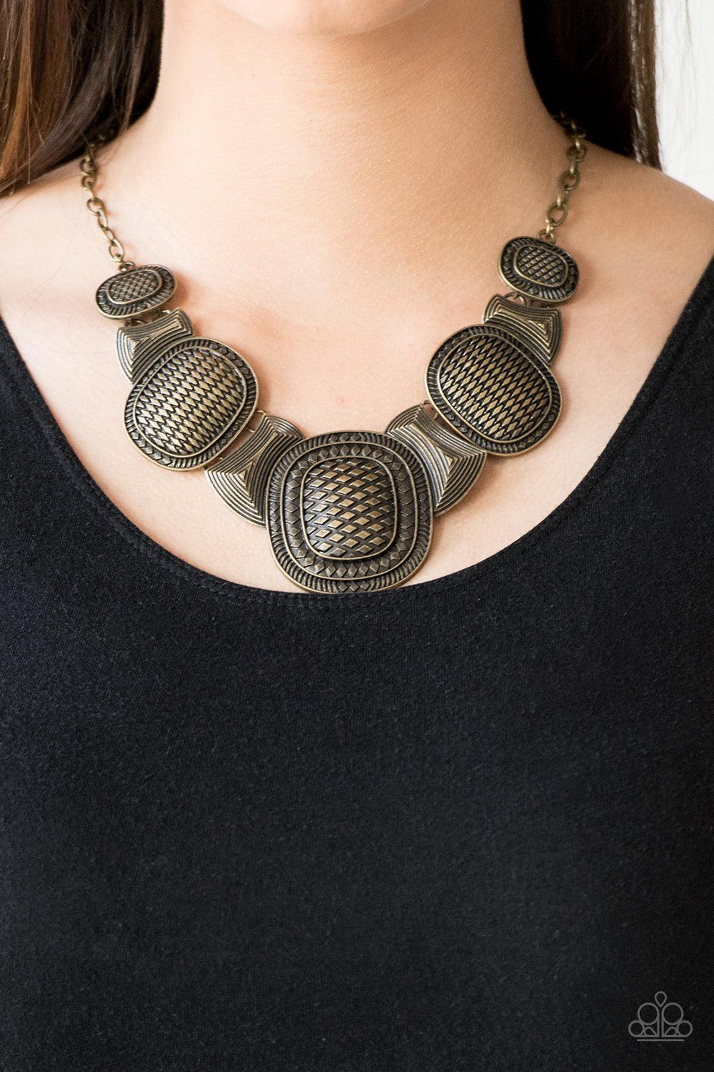 Paparazzi Accessories Prehistoric Powerhouse - Brass Radiating with geometric and linear details, ornate brass plates link below the collar for a bold tribal look. Features an adjustable clasp closure. Sold as one individual necklace. Includes one pair of