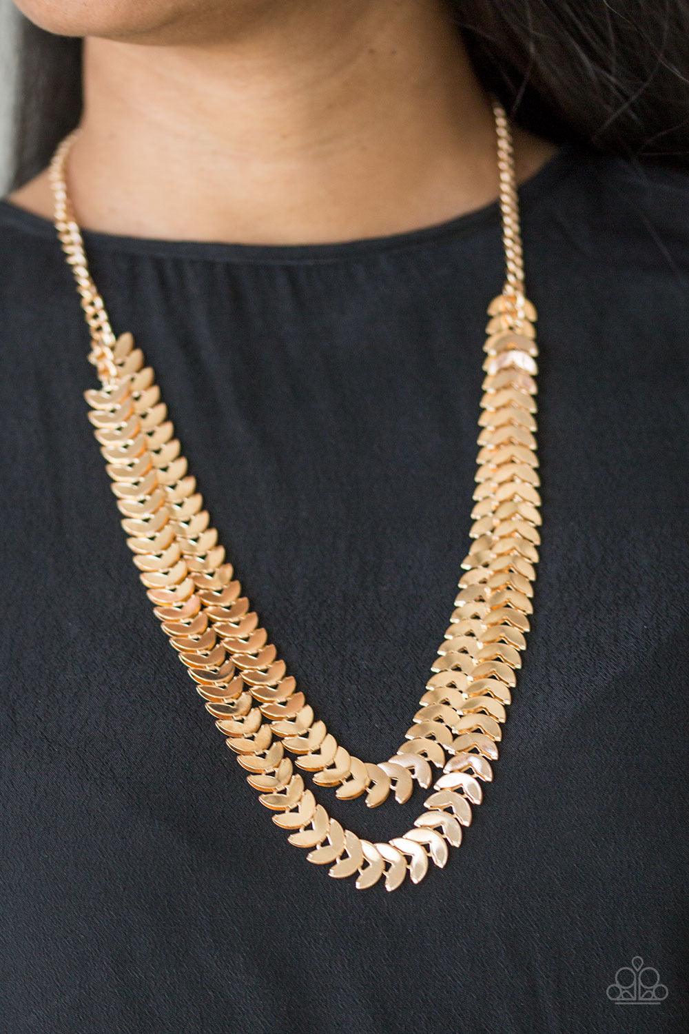 Paparazzi Accessories Industrial Illumination - Gold Glistening gold discs are folded in half and linked into two shimmery layers across the chest for an edgy industrial look. Features an adjustable clasp closure. Sold as one individual necklace. Includes