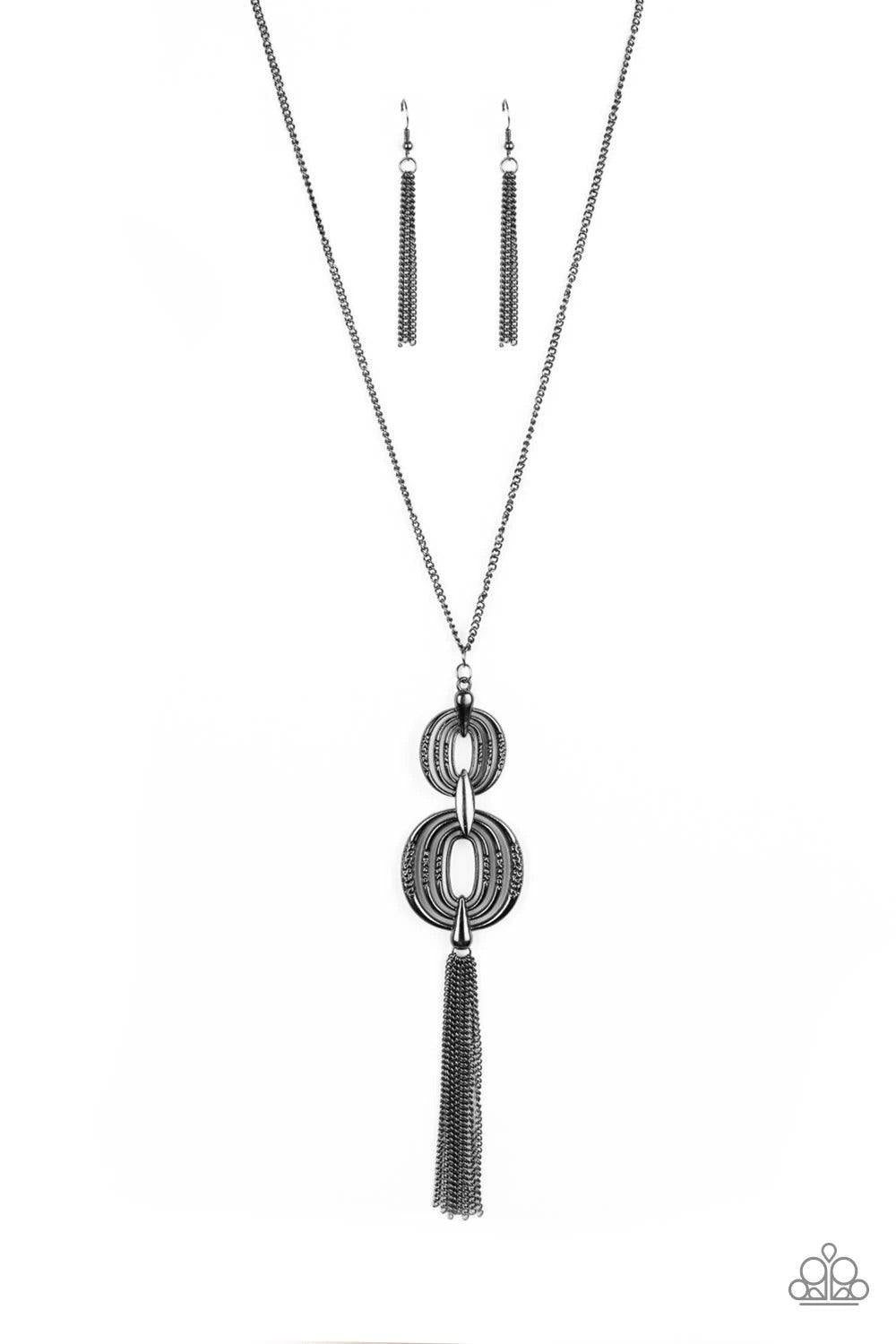 Paparazzi Accessories Timelessly Tasseled - Black Delicately hammered in sections of shimmer, gunmetal circular frames stack into a bold pendant at the bottom of a lengthened gunmetal chain. A shimmery gunmetal tassel swings from the bottom of the stacked