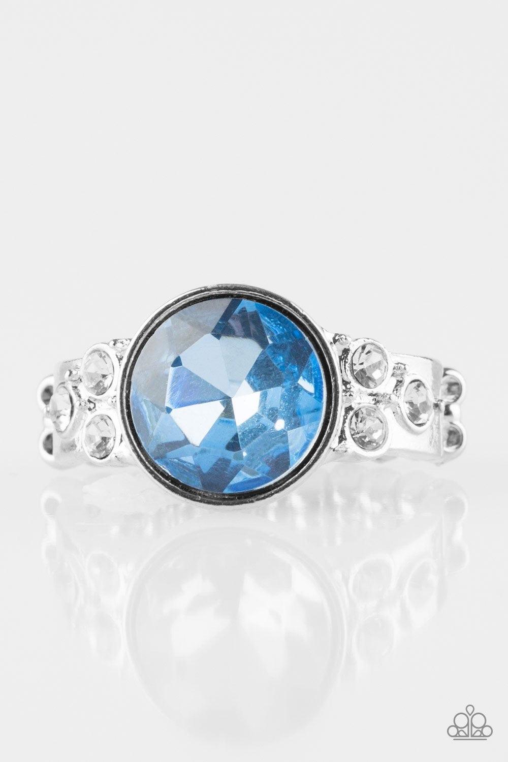 Paparazzi Accessories Poshly Pampered - Blue An oversized blue rhinestone is pressed into the center of a dainty silver band radiating with glassy white rhinestones for a glamorous look. Features a dainty stretchy band for a flexible fit. Jewelry