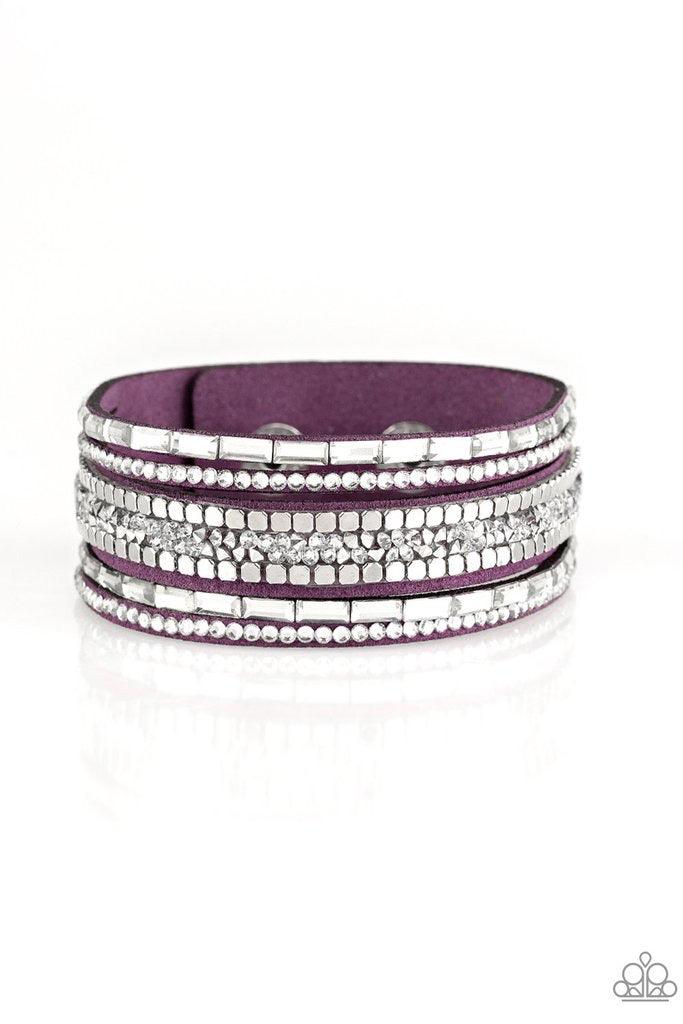 Paparazzi Accessories Rebel In Rhinestones - Purple Featuring round and emerald style cuts, glassy white rhinestones join flat silver cubes and metallic prism rhinestones along a purple suede band for a sassy look. Features an adjustable snap closure. Jew