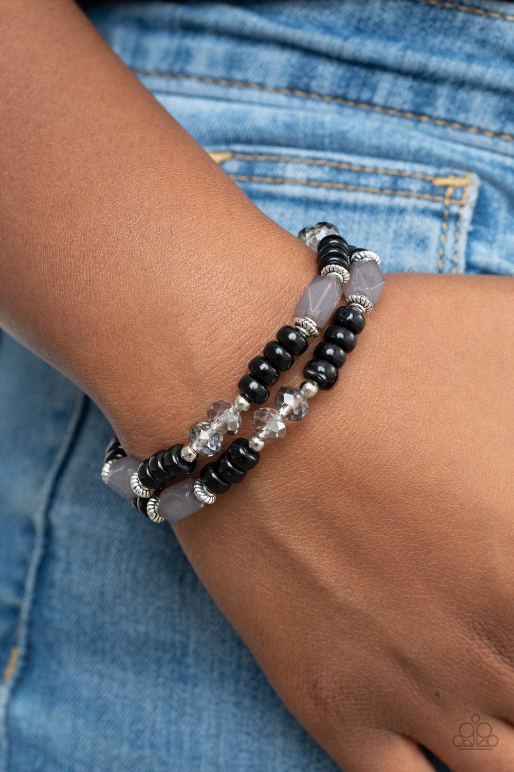 Paparazzi Accessories Delightfully Dainty - Black A shiny collection of smoky gems, dainty silver accents, white crystal-like beads, and polished black beads are threaded along stretchy bands around the wrist for a whimsically layered look. Sold as one pa