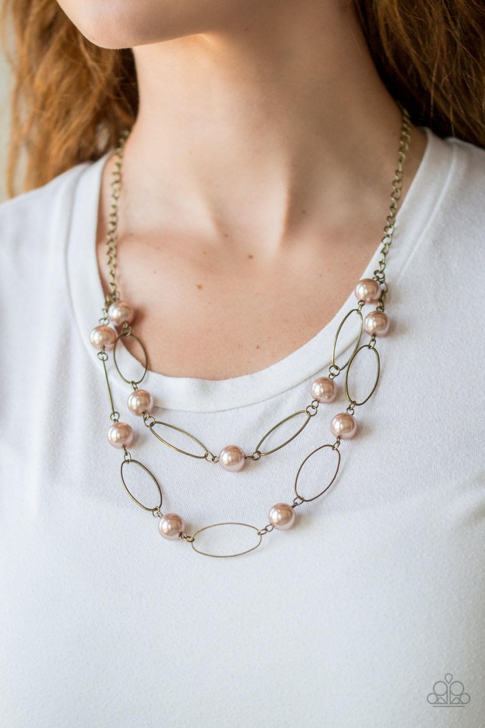 Paparazzi Accessories Best of Both POSH-ible Worlds - Brass Two rows of pearly brown beads and brass oval frames alternate below the collar, creating luminescent layers. Features an adjustable clasp closure. Sold as one individual necklace. Includes one p