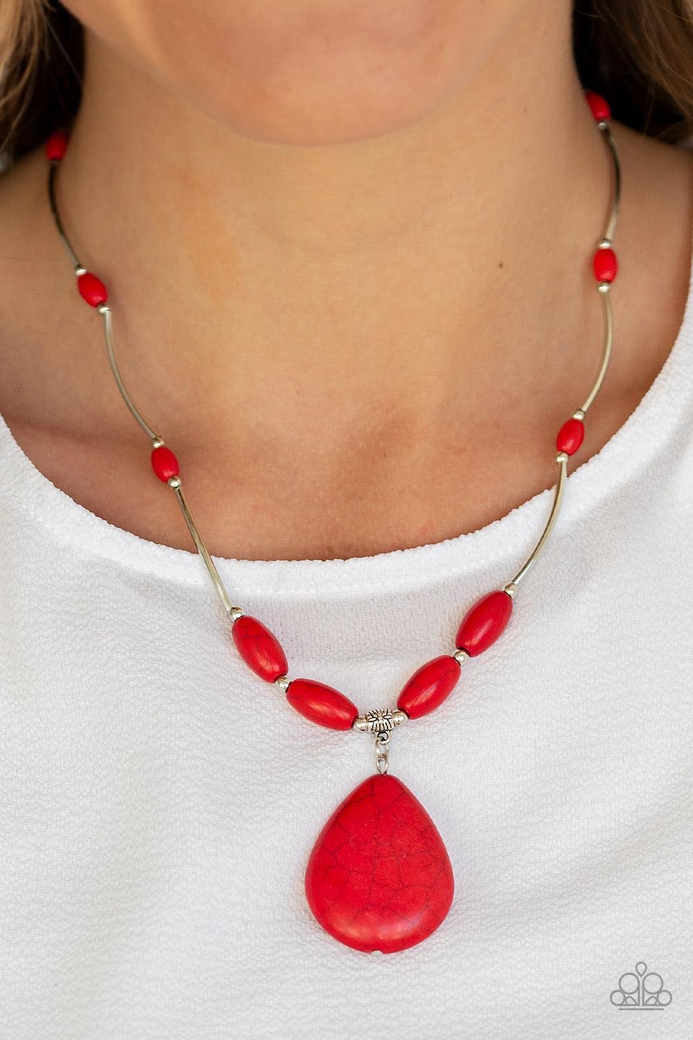 Paparazzi Accessories Explore The Elements - Red A collection of shiny silver beads and fiery red stone beads are threaded along an invisible wire below the collar. A dramatically oversized red stone teardrop pendant swings from the bottom of a seasonal f