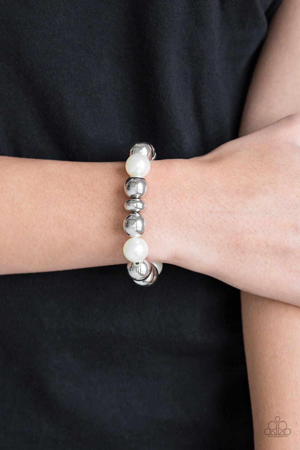 Paparazzi Accessories Upper Manhattan ~White A collection of shiny silver beads and pearly white beads are threaded along a stretchy band around the wrist for a refined look.