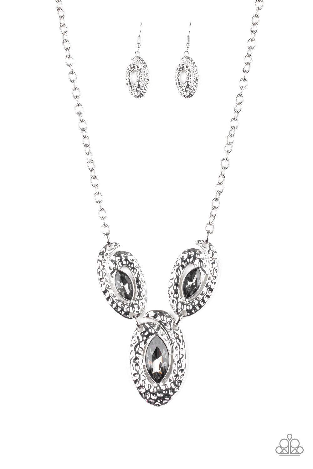 Paparazzi Accessories Metro Mystique - Silver A trio of smoky marquise-cut rhinestones are nestled inside swirls of hammered silver frames, creating a dazzling statement piece below the collar. Features an adjustable clasp closure. Jewelry