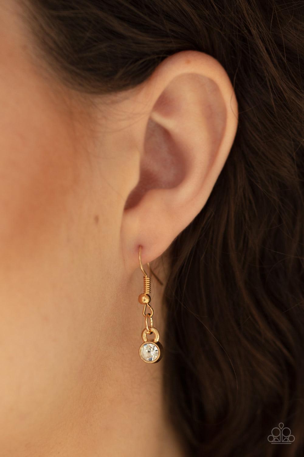 Paparazzi Accessories Lighthearted Luster ~Gold Encrusted in sections of glittery white rhinestones, two glistening gold hearts delicately join at the bottom of a lengthened gold chain for a charming look. Features an adjustable clasp closure.