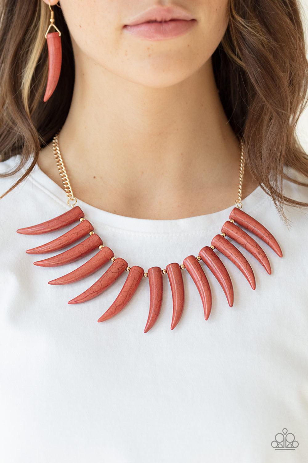 Paparazzi Accessories Tusk Tundra - Brown Infused with dainty gold beads, tusk-shaped Cinnamon Stick stone beads are threaded along an invisible wire below the collar, creating a wild fringe. Features an adjustable clasp closure. Sold as one individual ne