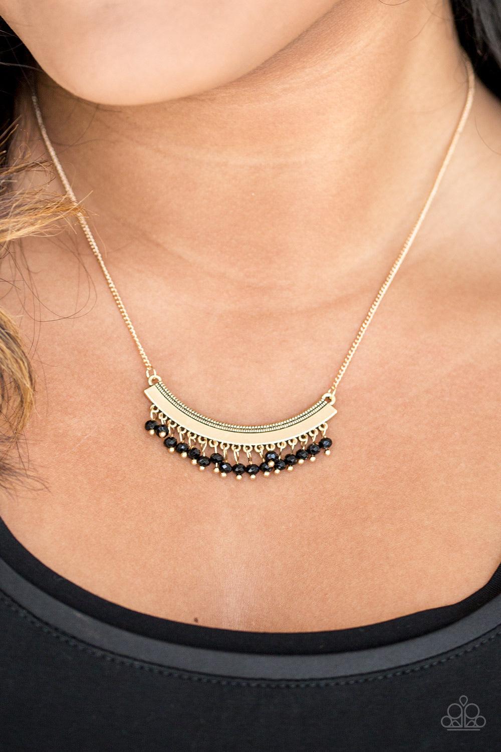 Paparazzi Accessories Fringe Fever - Gold Faceted black beads swing from the bottom of a glistening gold crescent, creating a dainty fringe below the collar for a playful tribal inspired look. Features an adjustable clasp closure. Sold as one individual n
