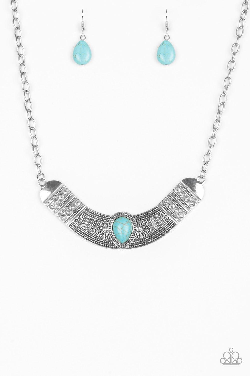 Paparazzi Accessories Very Venturous - Blue Embossed in floral and tribal inspired patterns, a shimmery silver crescent shaped frame swings below the collar in a fierce fashion. Chiseled into a tranquil teardrop, a refreshing turquoise stone is pressed in