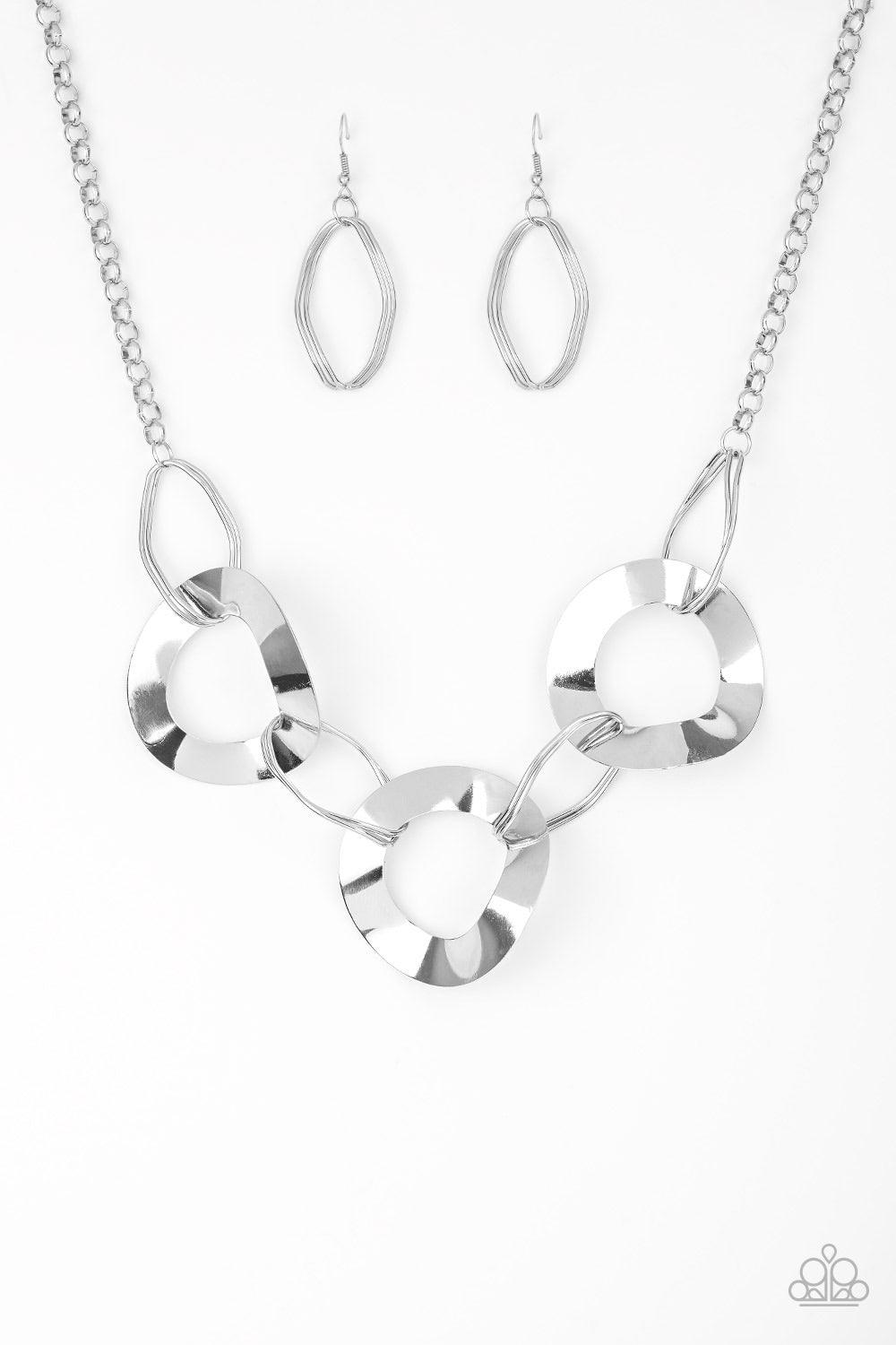 Paparazzi Accessories Modern Mechanics - Silver Featuring slightly warped surfaces, asymmetrical silver hoops link with reflective silver rings below the collar for a modern look. Features an adjustable clasp closure. Jewelry