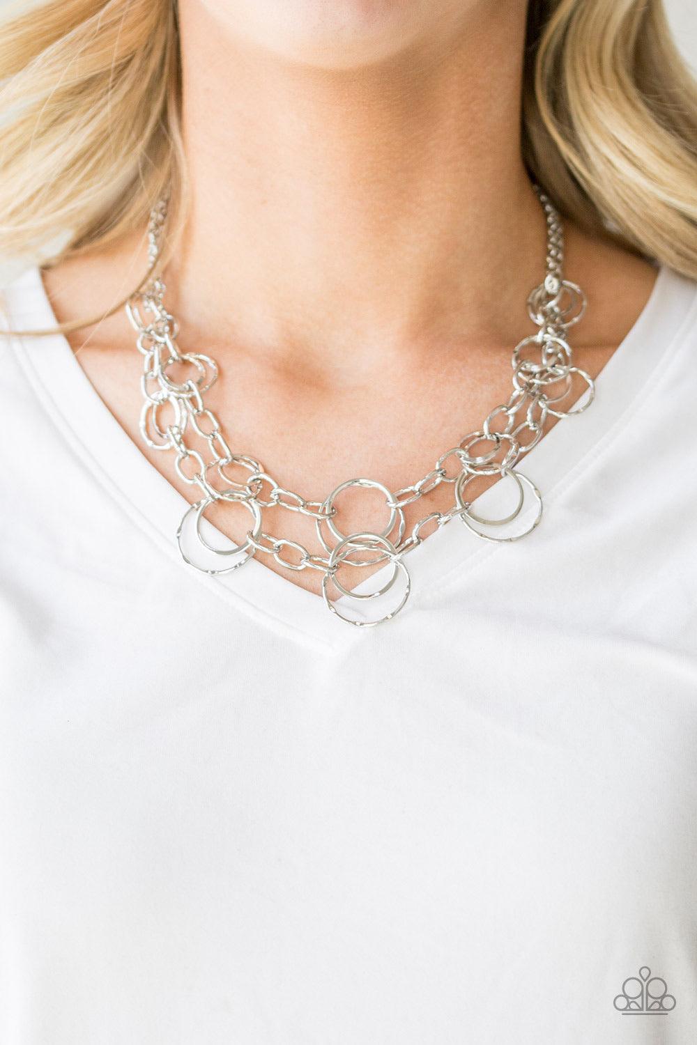 Paparazzi Accessories Urban Center ~Silver Mismatched silver hoops and rings link into two shimmery rows below the collar for a bold industrial look. Features an adjustable clasp closure. Sold as one individual necklace. Includes one pair of matching earr