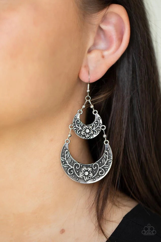 Paparazzi Accessories Springtime Gardens - White Dotted with dainty white rhinestone centers, studded silver half moon frames are embossed in leafy floral patterns as they link into a whimsical display. Earring attaches to a standard fishhook fitting. Sol