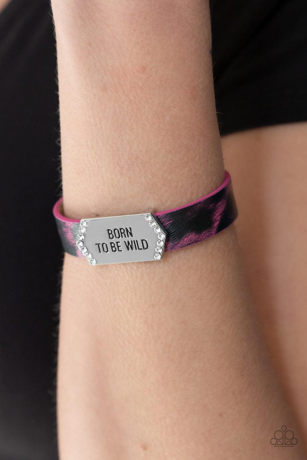 Paparazzi Accessories Born To Be Wild - Pink A white rhinestone encrusted silver frame stamped in the free-spirited phrase, "Born To Be Wild", slide along a shiny pink cheetah print leather band for a wild look. Features an adjustable snap closure. Jewelr