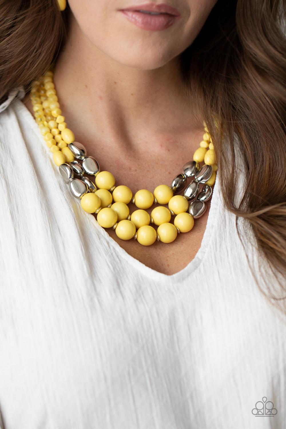 Paparazzi Accessories Flamingo Flamboyance - Yellow Featuring polished and glassy finishes, imperfect yellow and silver beads are threaded along three invisible wires, creating colorful layers below the collar. Features an adjustable clasp closure. Sold a