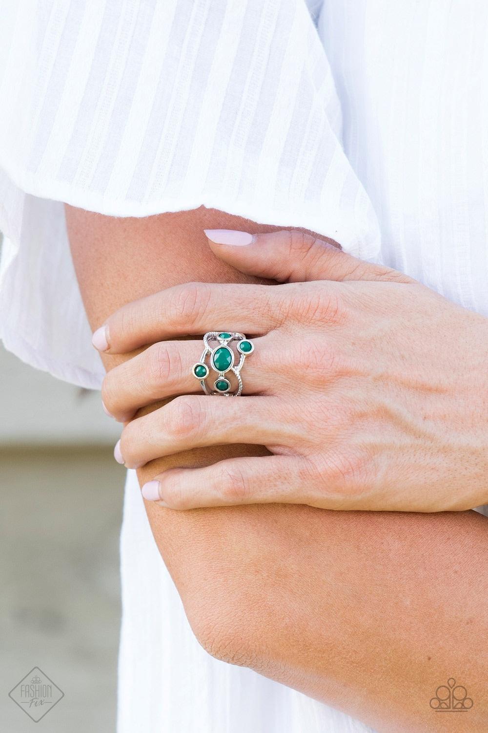 Paparazzi Accessories Carnival Catwalk - Green Featuring smooth and serrated surfaces, shimmery silver bars crisscross across the finger, coalescing into an airy band. Faceted Quetzal Green beads are sprinkled across the bands for a colorful finish. Featu
