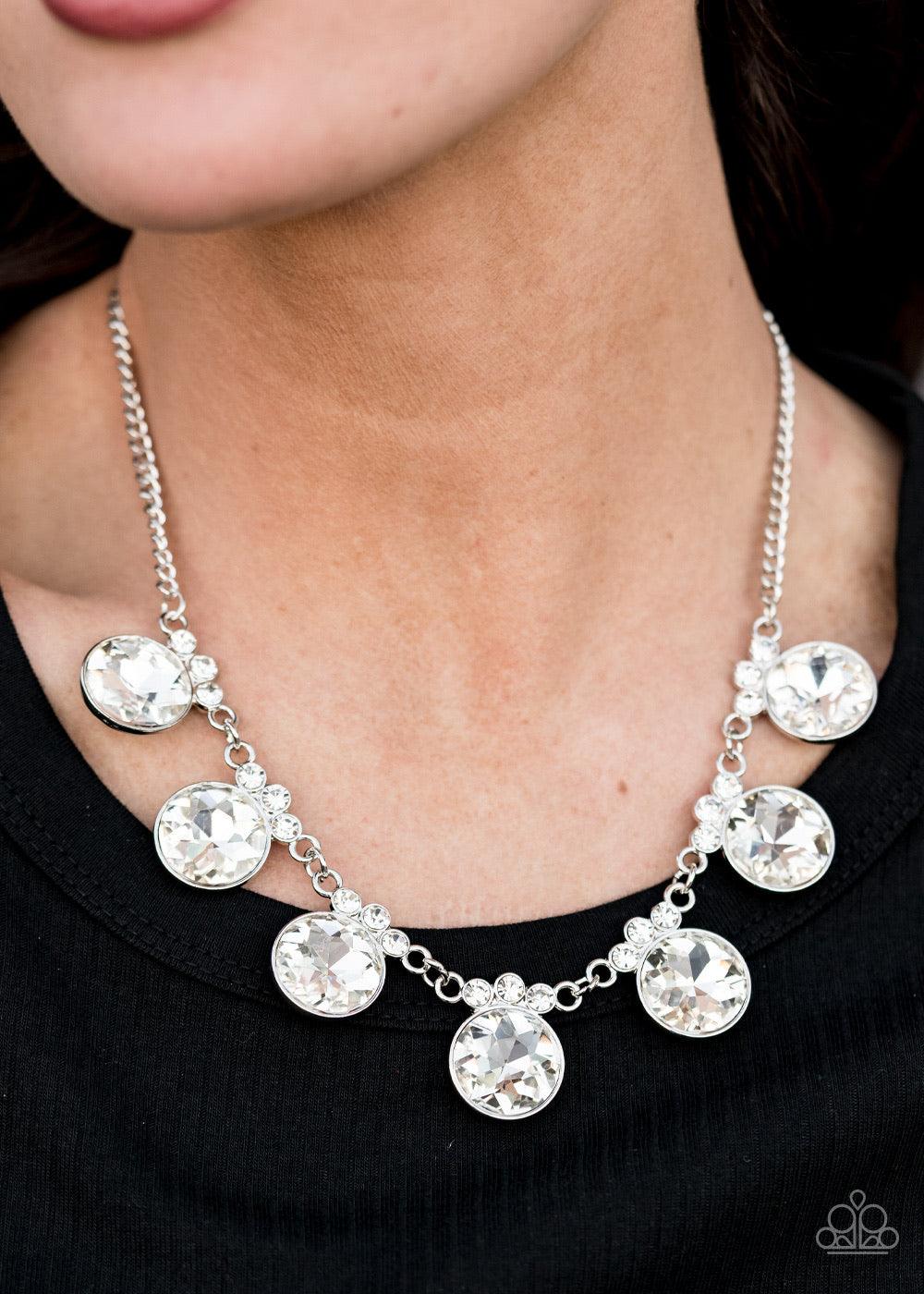 Paparazzi Accessories GLOW-Getter Glamour - White Crowned in a trio of dainty white rhinestones, an exaggerated display of oversized white gems delicately links below the collar for a glamorous glow. Features an adjustable clasp closure. Jewelry