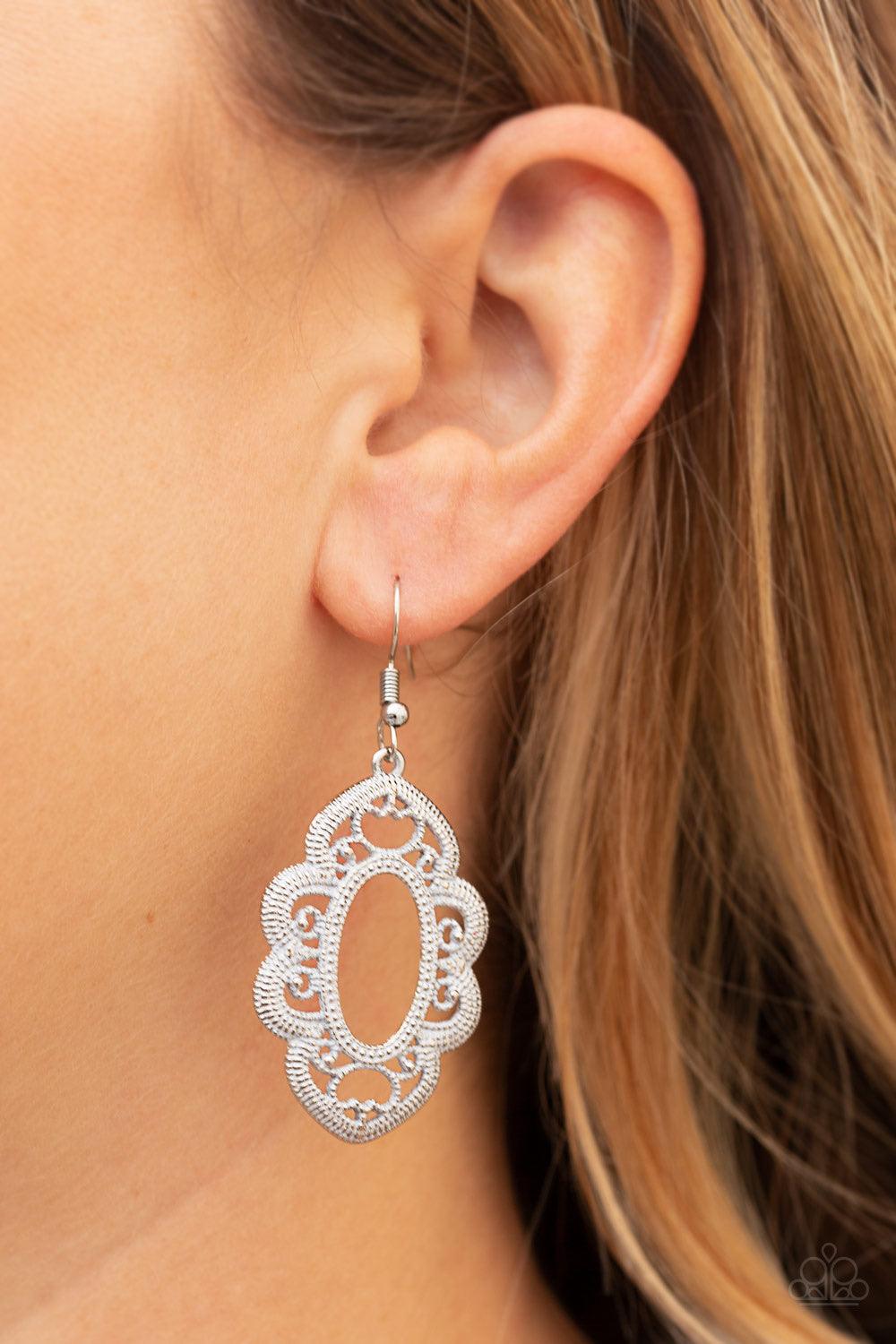 Paparazzi Accessories Mantras and Mandalas - White Brushed in a white finish, a studded silver filigree filled frame swings from the ear for a whimsical look. Earring attaches to a standard fishhook fitting. Sold as one pair of earrings. Jewelry