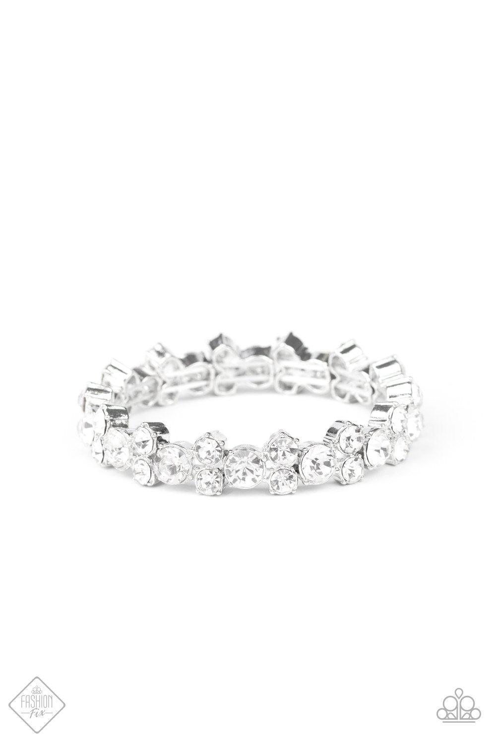 Paparazzi Accessories Here Comes The Bribe - White Featuring sleek silver frames, trios of glittery white rhinestones are threaded along stretchy bands around the wrist for a timeless shimmer. Jewelry