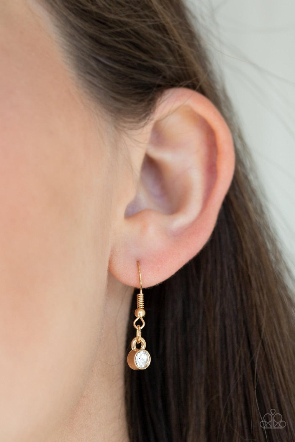 Paparazzi Accessories Urban District ~Gold Featuring round, oval, and emerald style cuts, glittery white rhinestone fittings link with mismatched gold rings below the collar for an edgy glamorous look. Features an adjustable clasp closure.