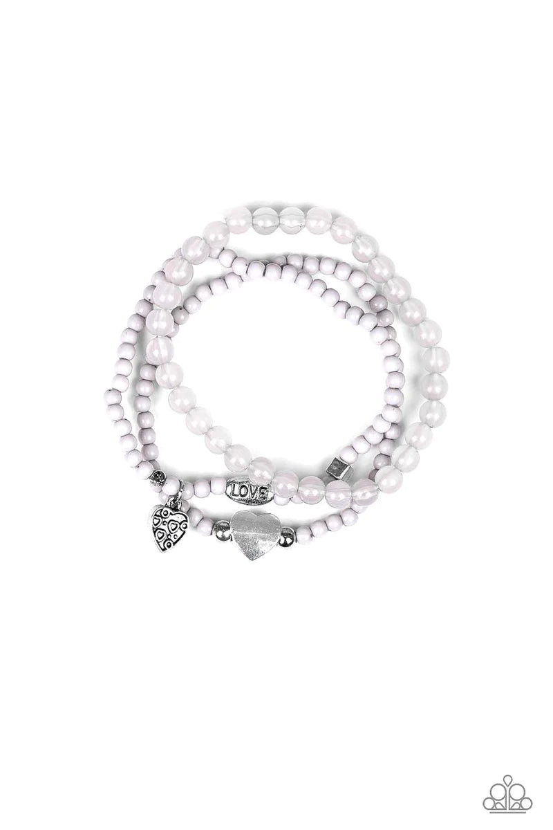 Paparazzi Accessories Really Romantic - Silver An array of glassy and polished gray beads are threaded along stretchy bands. Infused with silver accents, a collection of silver heart charms and a bead spelling out the word, "love", adorn the beaded strand