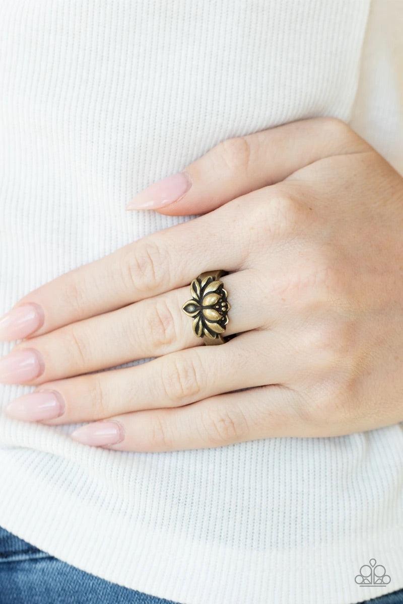 Paparazzi Accessories Lotus Crowns - Brass Brushed in antiqued shimmer, a lifelike brass lotus embellishes the center of a dainty brass band for a whimsical look. Features a dainty stretchy band for a flexible fit. Jewelry