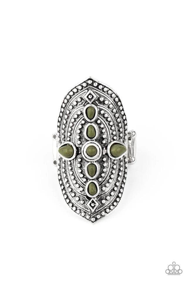 Paparazzi Accessories Shield In Place - Green A dainty collection of imperfect green stones adorn the center of an oversized frame radiating with antiqued studs for a bold tribal inspired look. Features a stretchy band for a flexible fit. Jewelry