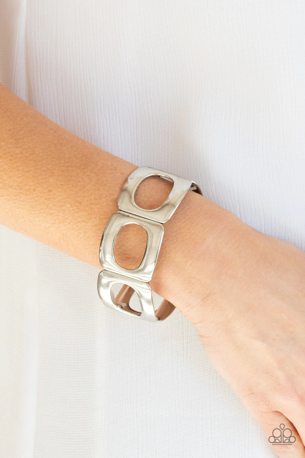 Paparazzi Accessories In OVAL Your Head - Silver Brushed in a gritty finish, airy ovals have been cut out of curved silver frames. Threaded along stretchy bands around the wrist, the airy frames allow the skin to peek through their centers for a natural f