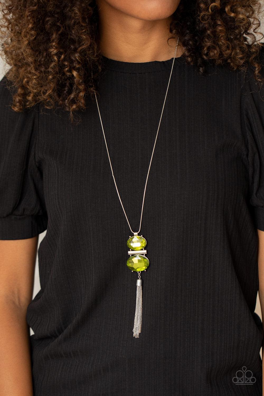 Paparazzi Accessories Runway Rival - Green A rectangular silver bar is nestled between two oversized oval green rhinestones, creating a stacked pendant at the bottom of a rounded silver snake chain. A shimmery silver chain tassel swings from the bottom, a