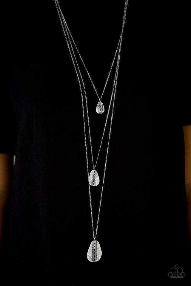 Paparazzi Accessories Sonoran Storm - Silver Gradually increasing in size, asymmetrical silver teardrops drip down the chest, creating rustic layers. The glistening teardrops are etched and studded down the center, adding tactile texture to the tribal ins