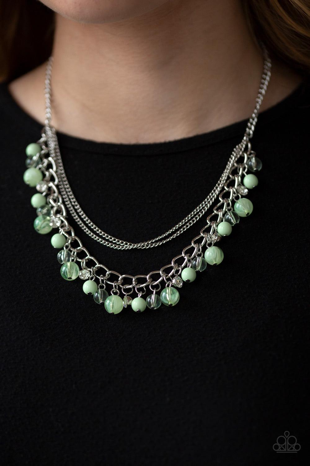 Paparazzi Accessories Wait And Sea - Green Infused with layers of mismatched silver chains, glassy, polished green, and glittery white rhinestones swing from the bottom of a bold silver chain, creating a bubbly fringe below the collar. Features an adjusta