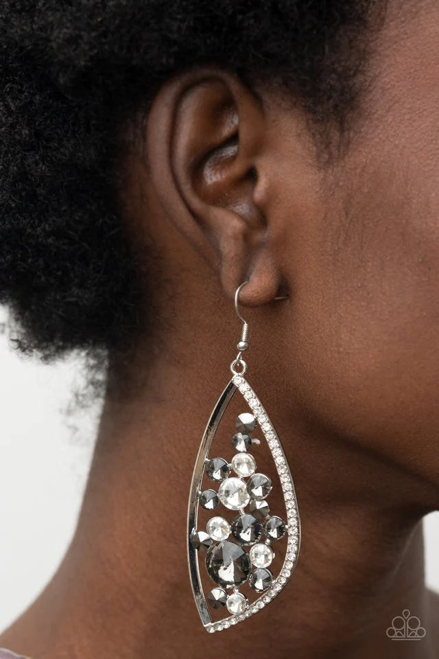 Paparazzi Accessories Sweetly Effervescent - Silver A bubbly collection of white, smoky, and hematite rhinestones coalesce inside an asymmetrical silver frame. One side of the frame is encrusted in glassy white rhinestones, adding a refined flair to the b