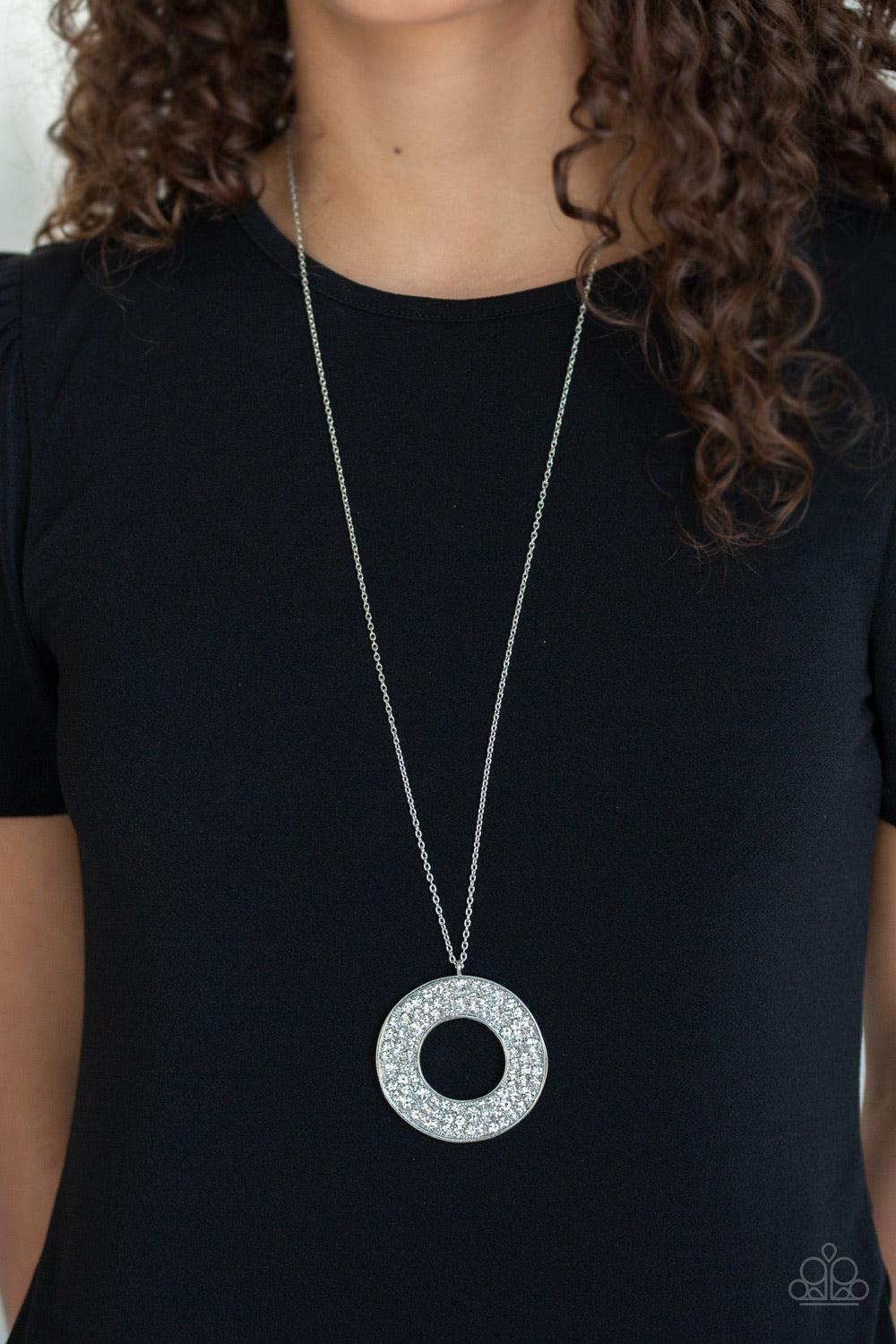 Paparazzi Accessories Bad HEIR Day - White Encrusted in row after row of glittery white rhinestones, an oversized round pendant swings from the bottom of a lengthened silver chain for a blinding look. Features an adjustable clasp closure. Jewelry