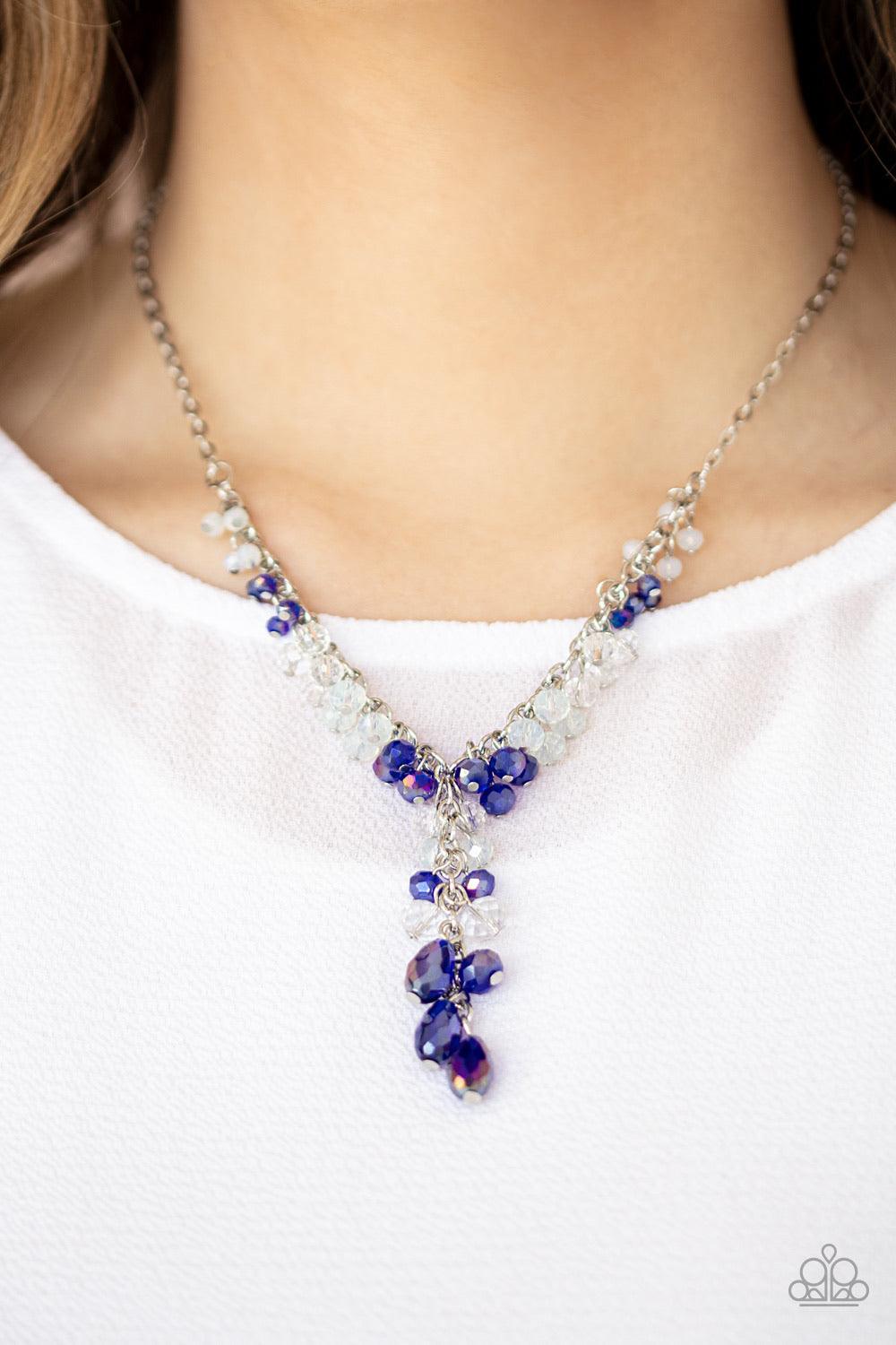 Paparazzi Accessories Iridescent Illumination - Blue A fringe of white, opaque, and iridescent blue crystal-like beads dangle from the bottom of a shimmery silver chain. Matching round and teardrop beads cascade from an extended silver chain at the center