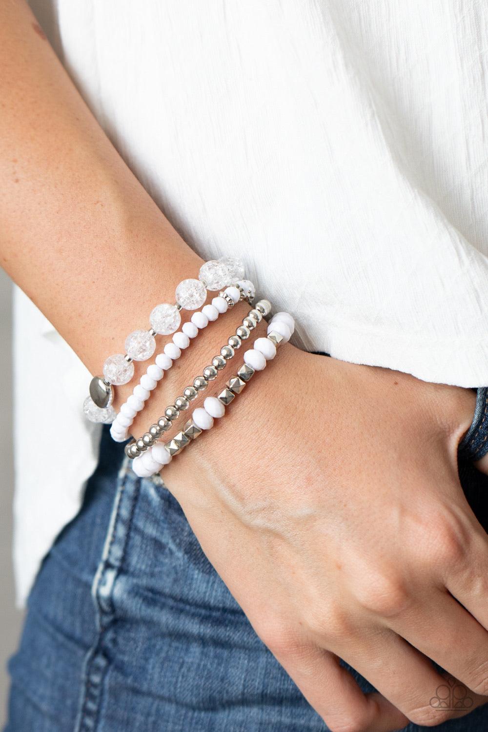 Paparazzi Accessories Layered Luster - White A mismatched assortment of silver, white, and crackling white glass-like beads are threaded along stretchy bands around the wrist, creating colorful layers. Sold as one set of four bracelets. Jewelry