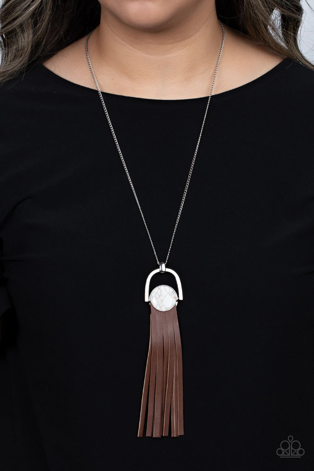 Paparazzi Accessories Winslow Wanderer - White Strips of brown leather fan out from the bottom of a round white stone that is threaded along a metal rod that attaches to the bottom of a silver horseshoe frame. The earthy pendant swings from the bottom of