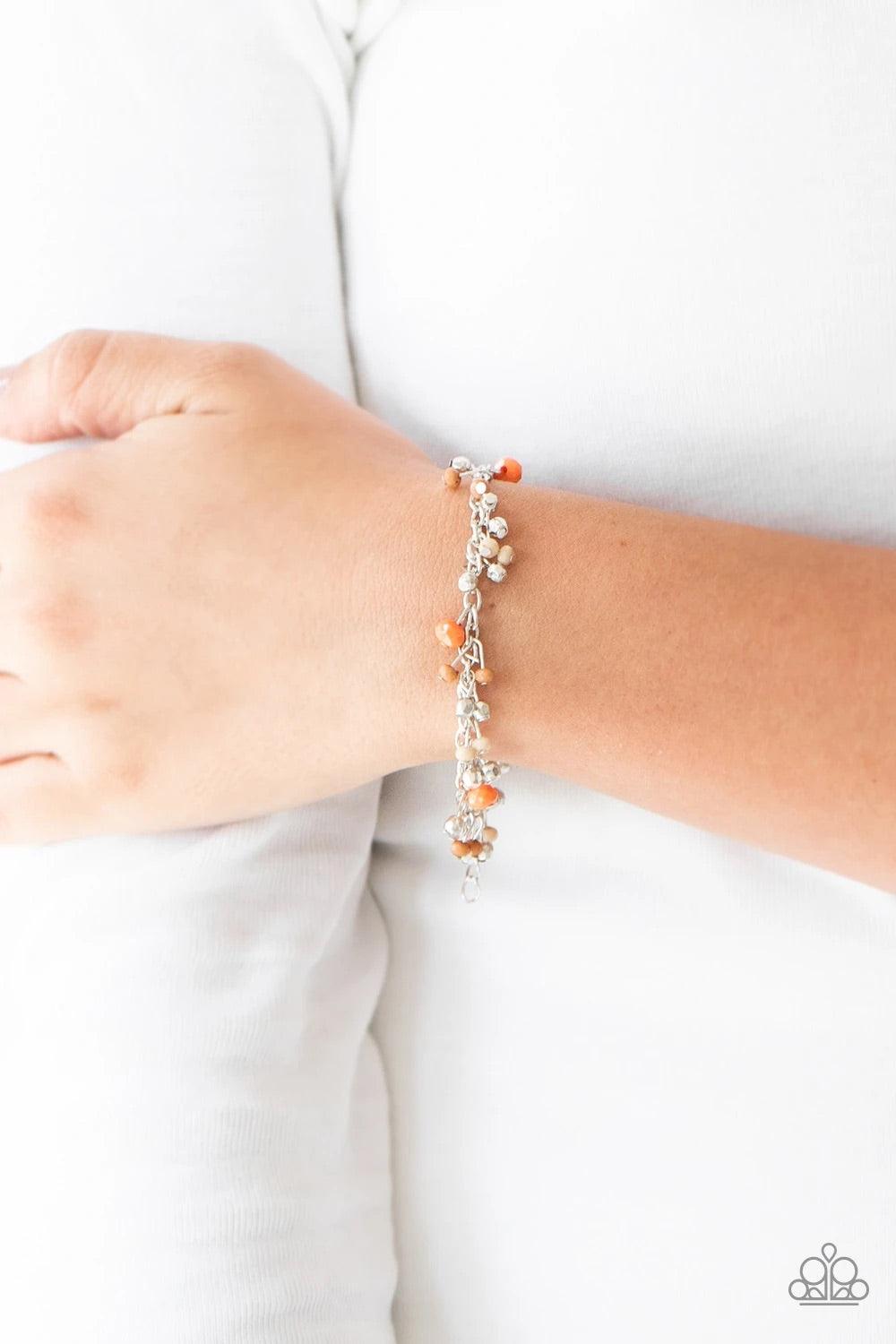 Paparazzi Accessories Aquatic Adventure - Orange A variety of faceted orange, Almond Buff, and Meerkat beads swing from a shimmery silver chain, creating a flirtatious fringe around the wrist. Faceted silver beads trickle between the colorful beads, addin