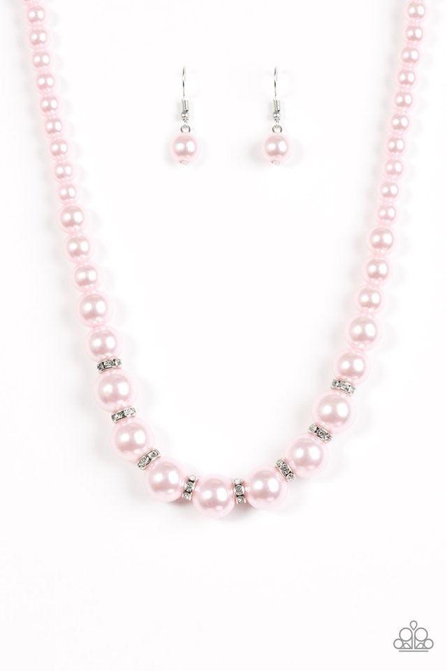 Paparazzi Accessories Showtime Shimmer - Pink Gradually increasing in size near the bottom, classic pink pearls drape below the collar. Rhinestone encrusted rings are sprinkled between the dramatic pearls, adding sparkling accents to the timeless pearl pa